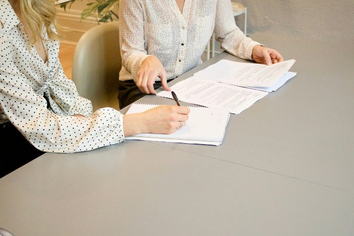 woman signing paperwork from Employment relations authority